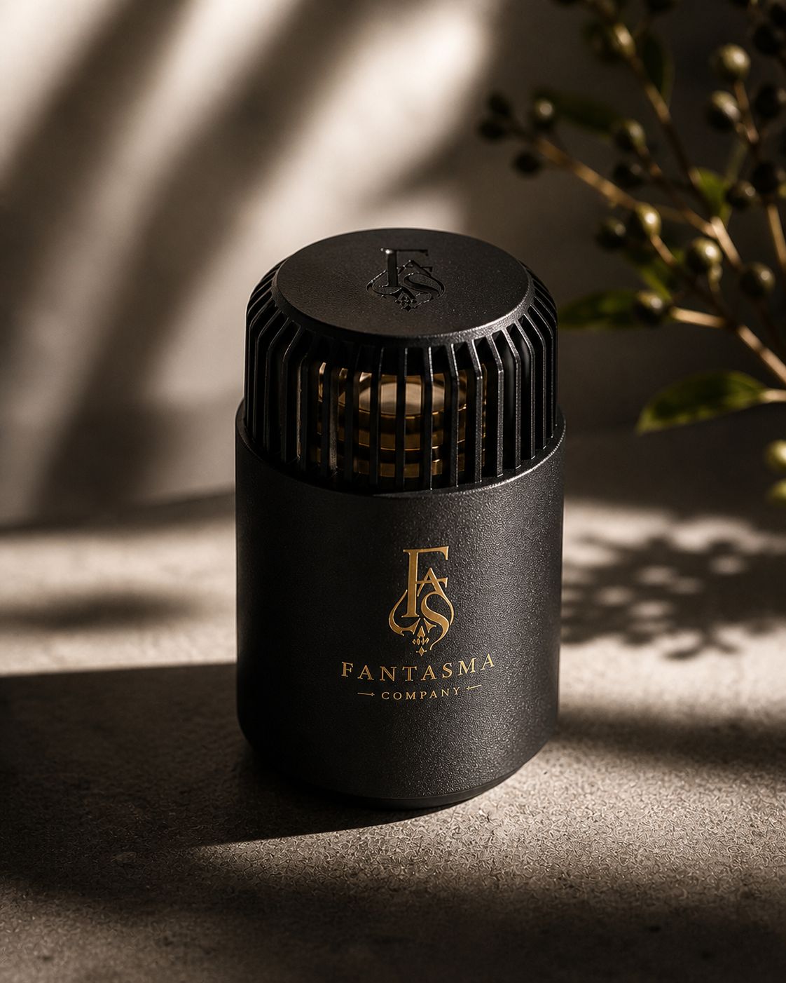 Fantasma black vented aroma diffuser on a textured surface.